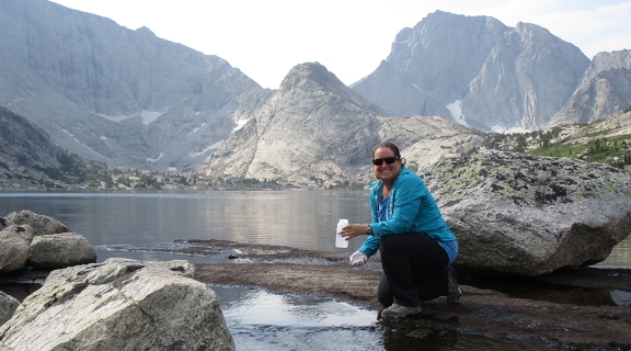 Leora Nanus at alpine lake surrounded by mountains
